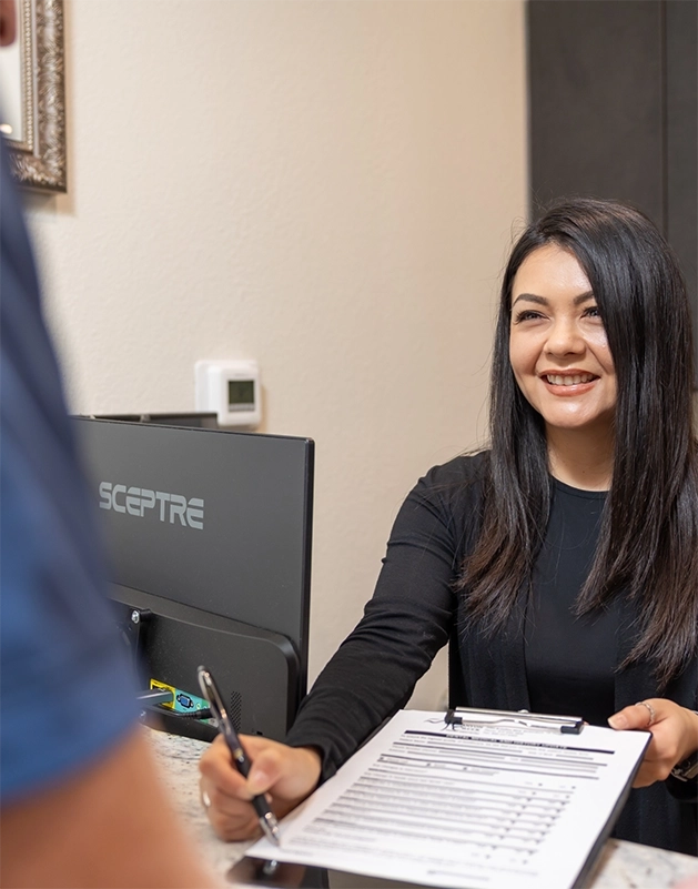Dental team member handing a clipboard to a patient