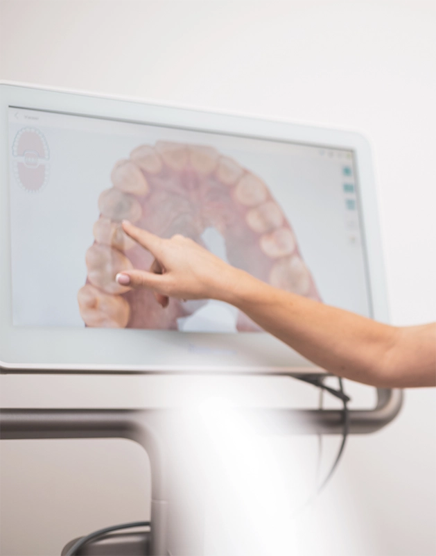 Dentist pointing to a screen with an impression of teeth