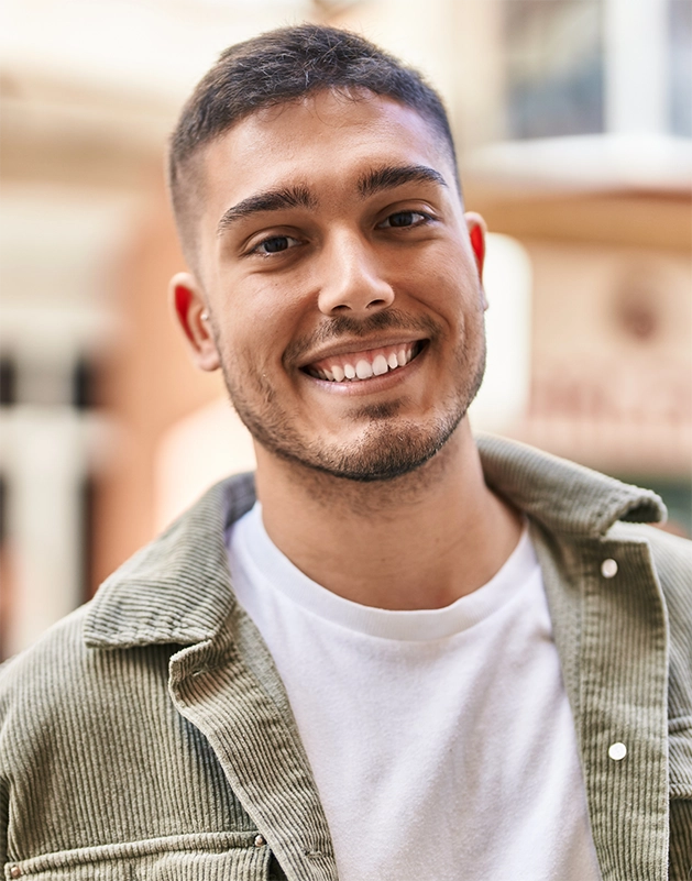 Young man in a light brown jacket smiling
