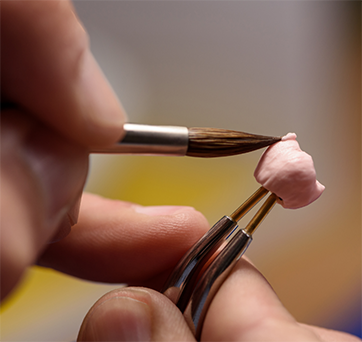Ceramist adjusting a dental crown
