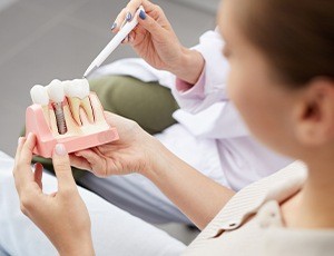 dentist showing a patient how dental implants work