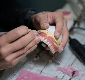 Dental lab worker adjusting a denture