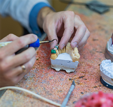 Dental professional working on a denture
