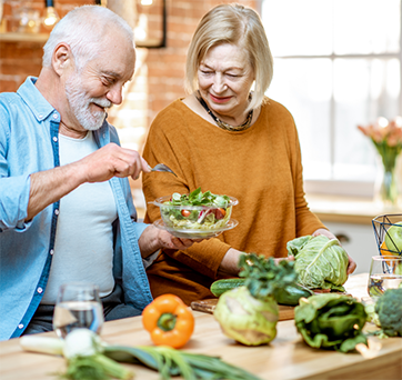 Senior couple making salads