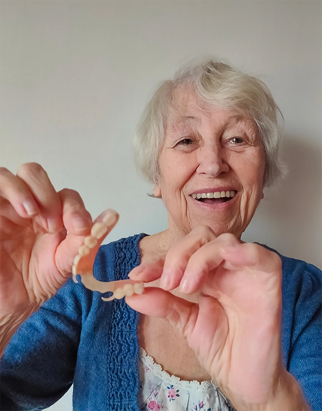 Senior woman showing off her partial denture