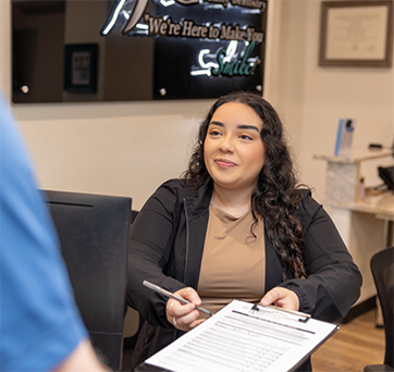 Dental team member giving paperwork to a patient