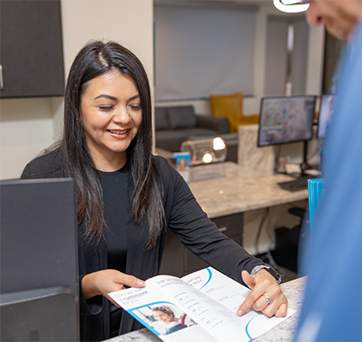 Dental team member showing a pamphlet to a patient