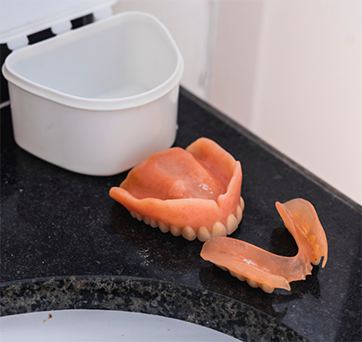 Dentures resting on a bathroom counter