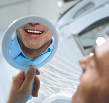 Man looking at his smile in a mirror
