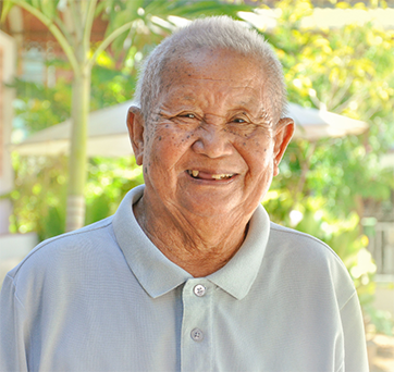 Senior man with missing teeth smiling outside