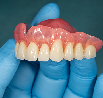 Dentist holding a full denture