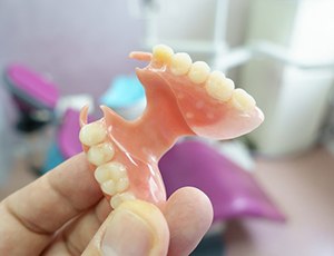 A hand holding a removable denture