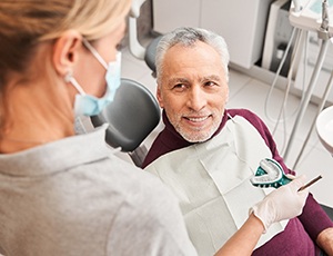 A dentist presenting a patient with dental impression molds for dentures