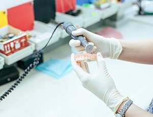 a lab technician polishing dentures