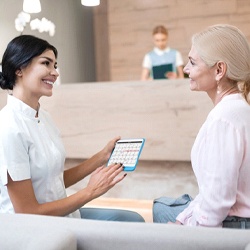 Dental assistant reviewing the cost of emergency dentistry in Richardson with patient