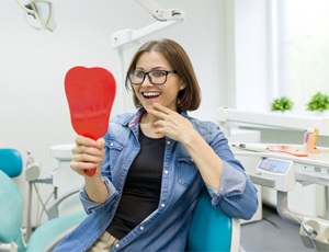 Woman with implant dentures looking at her smile