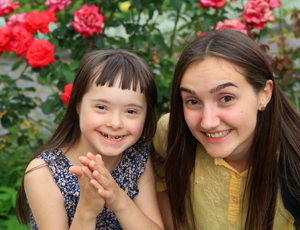 Smiling teen girl and preteen girl outdoors