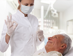 Dentist talking to senior man in dental chair