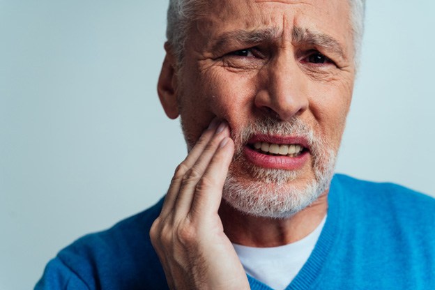Man holding cheek in pain