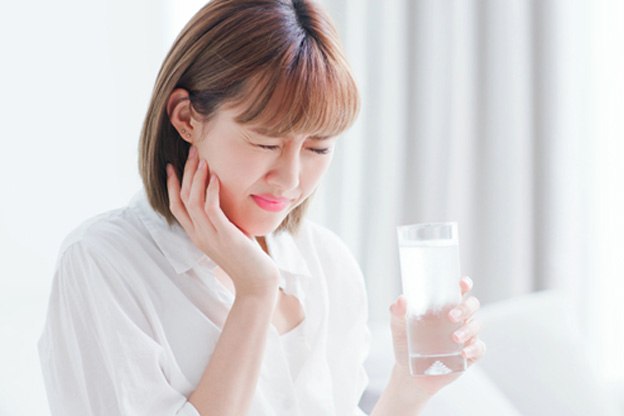 woman holding jaw in pain