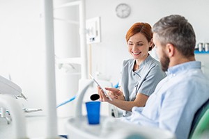 Dental assistant smiling while reviewing information with patient