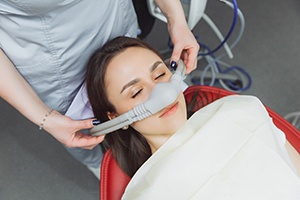 Dental assistant placing nasal mask over patient's nose