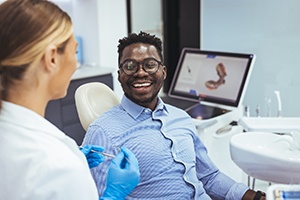 Man smiling at dentist while sitting in treatment chair