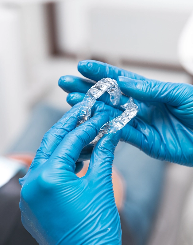 Dentist holding clear aligners
