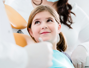 Smiling young girl in dental chair for pediatric dentistry