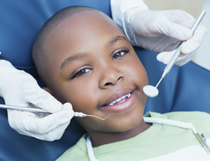 Smiling young boy in dental chair during pediatric dentistry visit