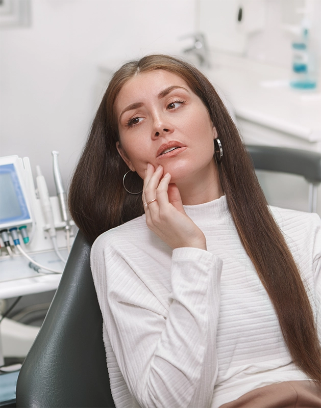 Dental patient holding the side of her cheek in pain