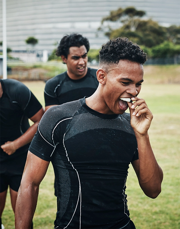 Athlete placing a mouthguard over his teeth