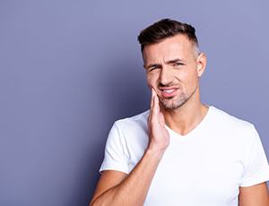 Man touching his face, wearing concerned expression