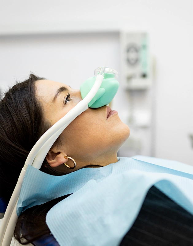 Dental patieng with a nitrous oxide mask on her nose