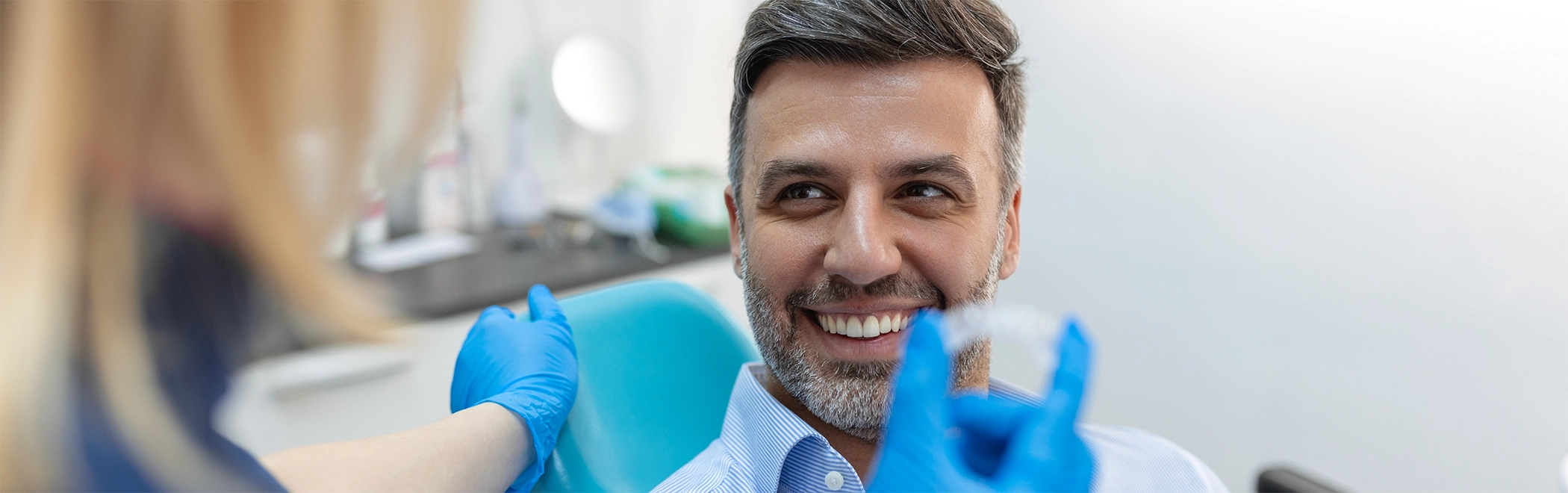 Dentist showing a clear aligner to a patient