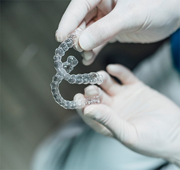 Dentist holding two clear aligners