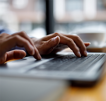 Hands typing on a laptop