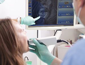 Woman and dentist looking at photos captured with intraoral camera