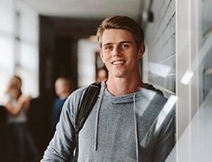 Young man smiling at school after tooth extraction