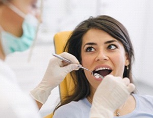Young woman receiving dental exam after tooth extraction