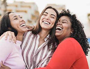 Three female friends smiling together after a visit to their United Healthcare dentist in Richardson
