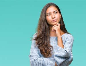 Woman wondering about veneers in Richardson on teal background