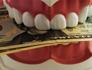 Money clenched in a set of teeth