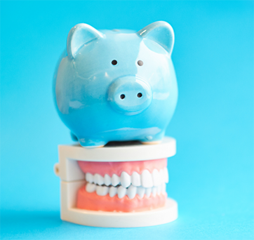 Piggy bank sitting on a model of the teeth