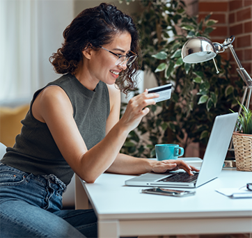 Woman entering her credit card information onto a laptop