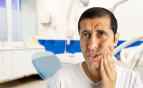 Man holding the side of his face in pain