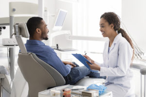 Person in pain sits next to an emergency dentist in Richardson