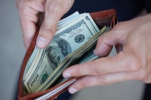 person holding wallet of money