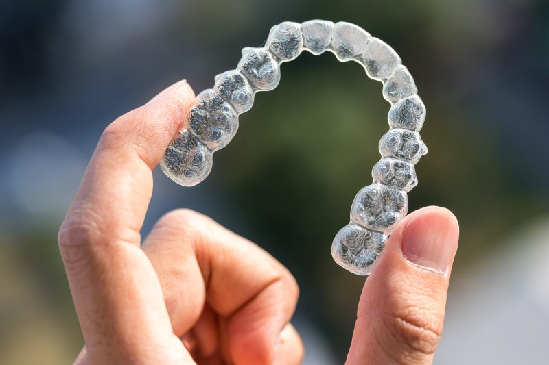 Close-up of a person holding an Invisalign tray