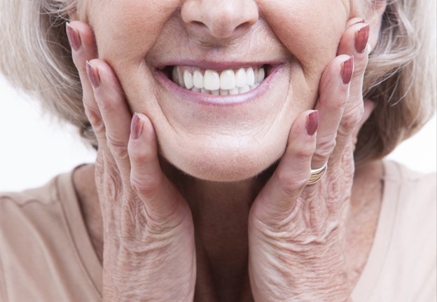 older person wearing dentures and smiling